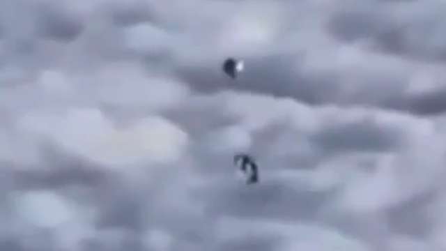 2 Silver UFOs caught on film from the window of a plane.