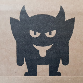 The Dark Imp in black on cardboard box