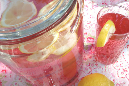 pink lemonade in a glass beverage dispenser. cute little cupcakes and cakes 