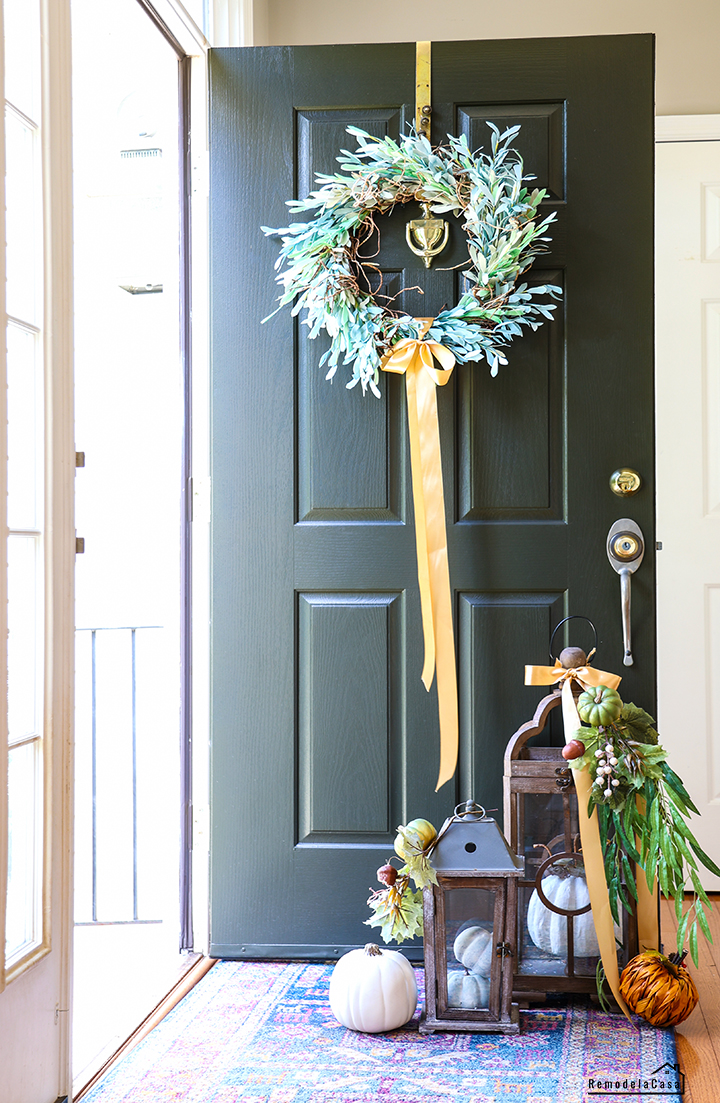 Front door for Fall with wreath and lanterns full of pumpkins
