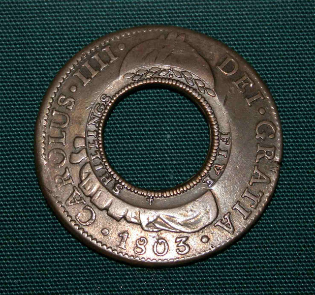 O Holey Dollar, foi um real furado adotado pela Australia,  British Museum. O centro dava uma moeda de menor valor