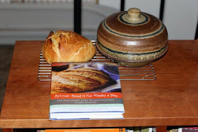 bread on the left, cloche on the right, cook book in front