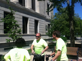 people in bike gear in front of office building on sunny day