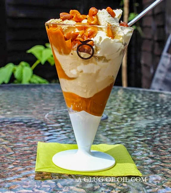 Ice cream sundae with caramel and caramelised peanuts.