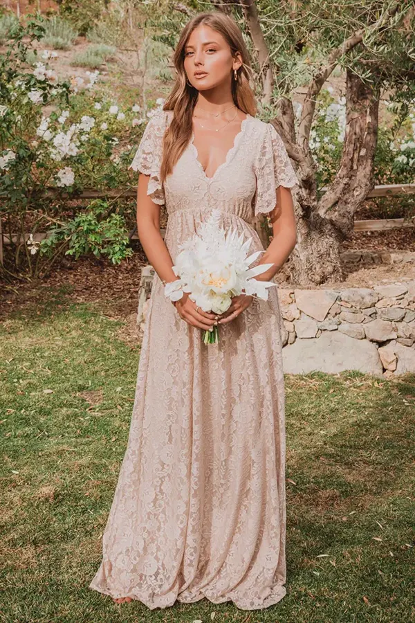 a beautiful bridesmaid in a beige minimalist dress posing for the camera