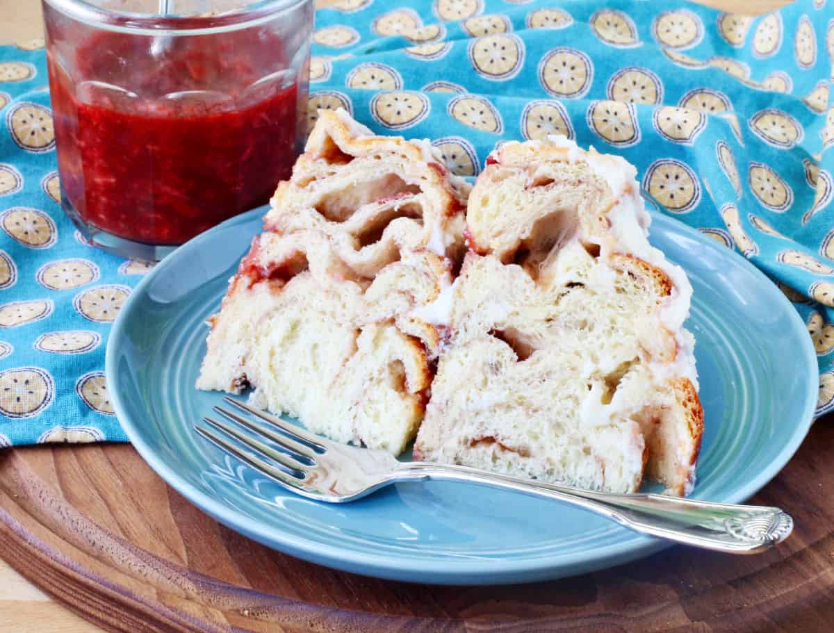 Fresh Strawberry Cinnamon Roll Cake Slice drizzled with jam.