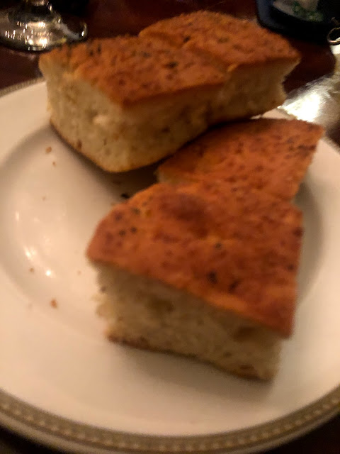 Two pieces of fresh foccaccia on a plain white plate