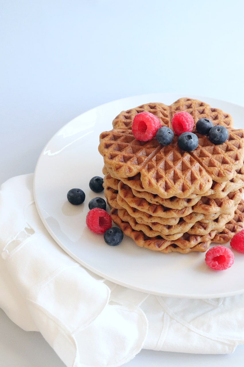 Fluffy waffles made with banana and protein powder on a plate with berries