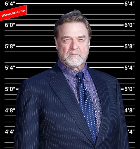 John Goodman standing in front of a height chart