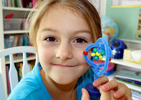 Using Janice VanCleave's "83. Building Blocks" experiment as a guide, Tessa created a model of a lithium atom with a plastic milk jug cap, pipe cleaners and colored pony beads.