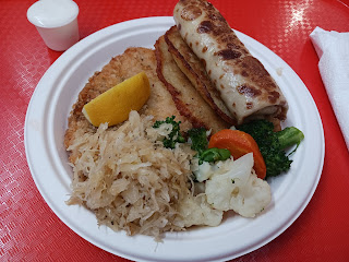 Combo plate featuring chicken schnitzel, potato latkes, and a blintz.