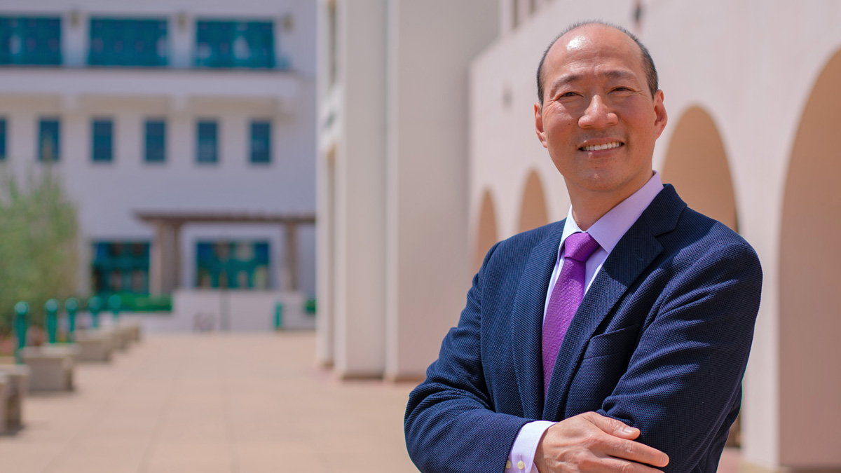 A smiling Y. Barry Chung stands on the SDSU campus on a sunny day.