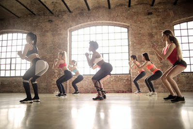 group-of-women-doing-squats-inside-the-building