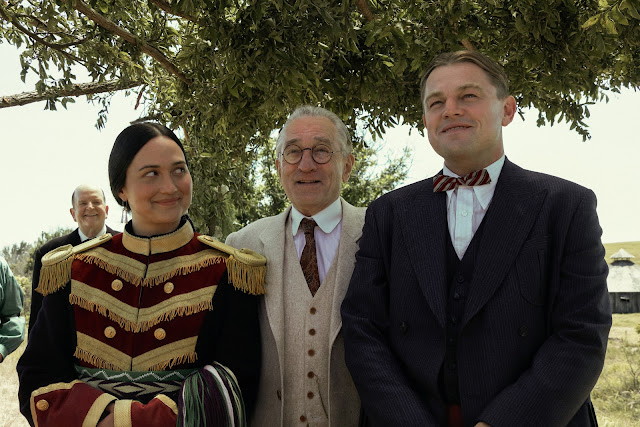 A man stands behind a man and woman who are getting married