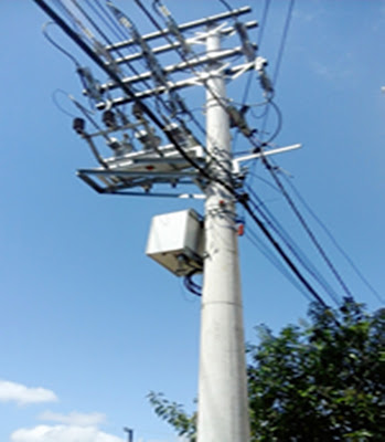 A foto mostra um poste da rede de transmissão de energia elétrica na rua, mas sem luz por falta de manutenção.