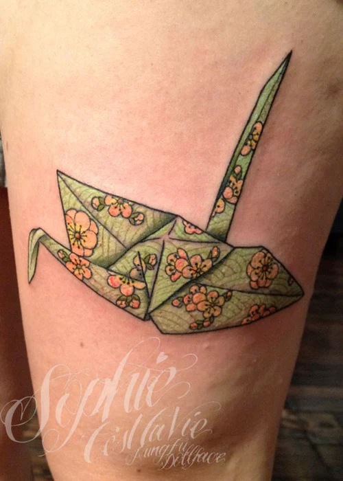 vemos la pierna de una mujer, llev un gran tatuaje de rna origami