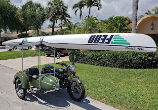 Motorcycle and sidecar with kayak on top.