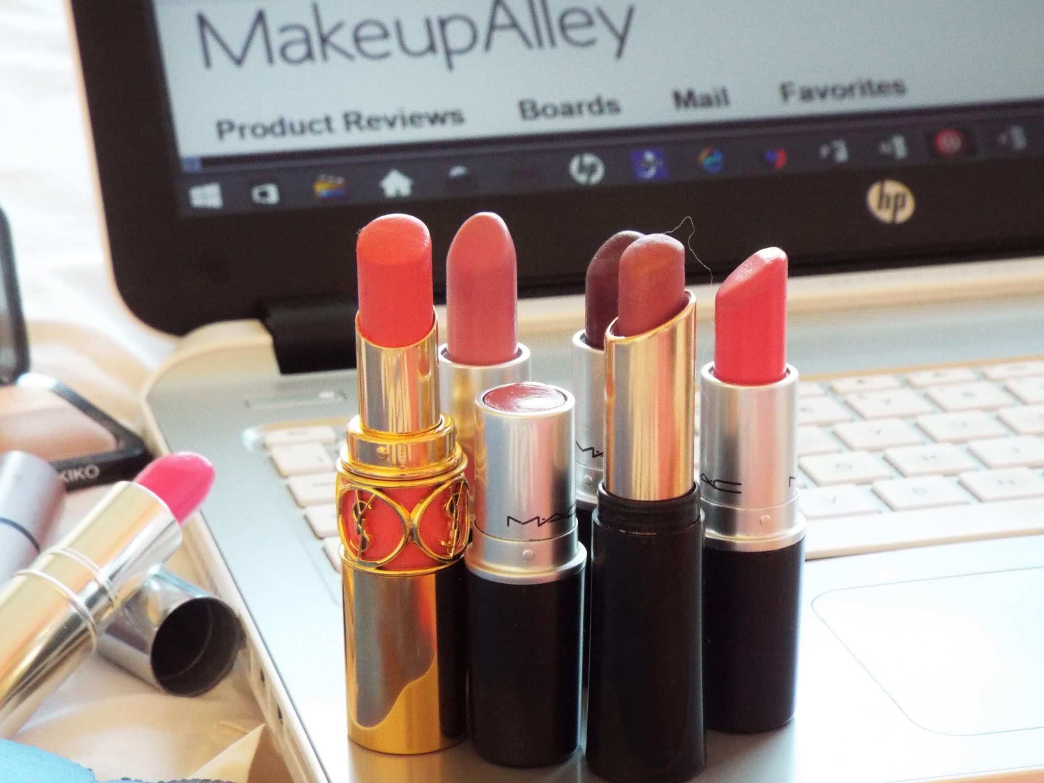 Group of lipsticks, YSL, MAC, No7, sat on my laptop with Makeup Alley website on screen.