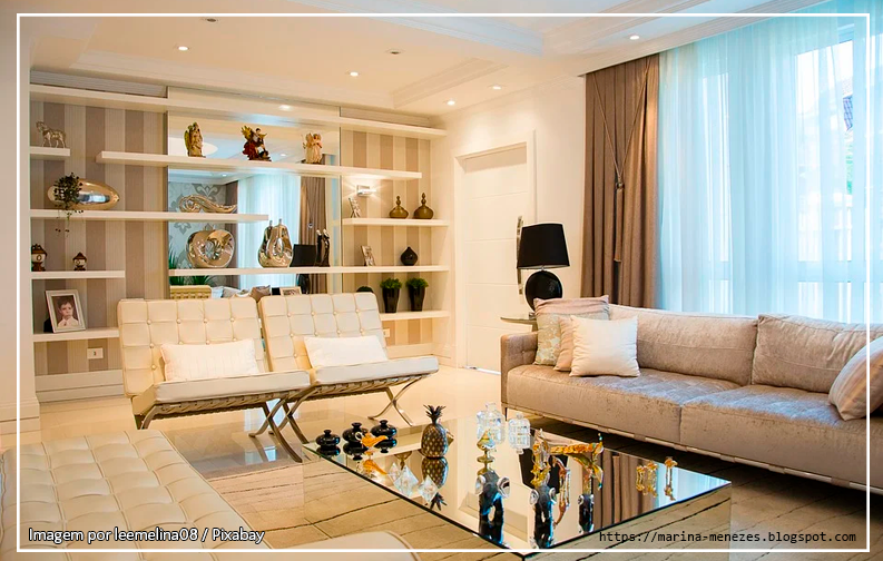 A imagem mostra uma sala com uma estante ao fundo, além de dois sofás decorados com almofadas coloridas