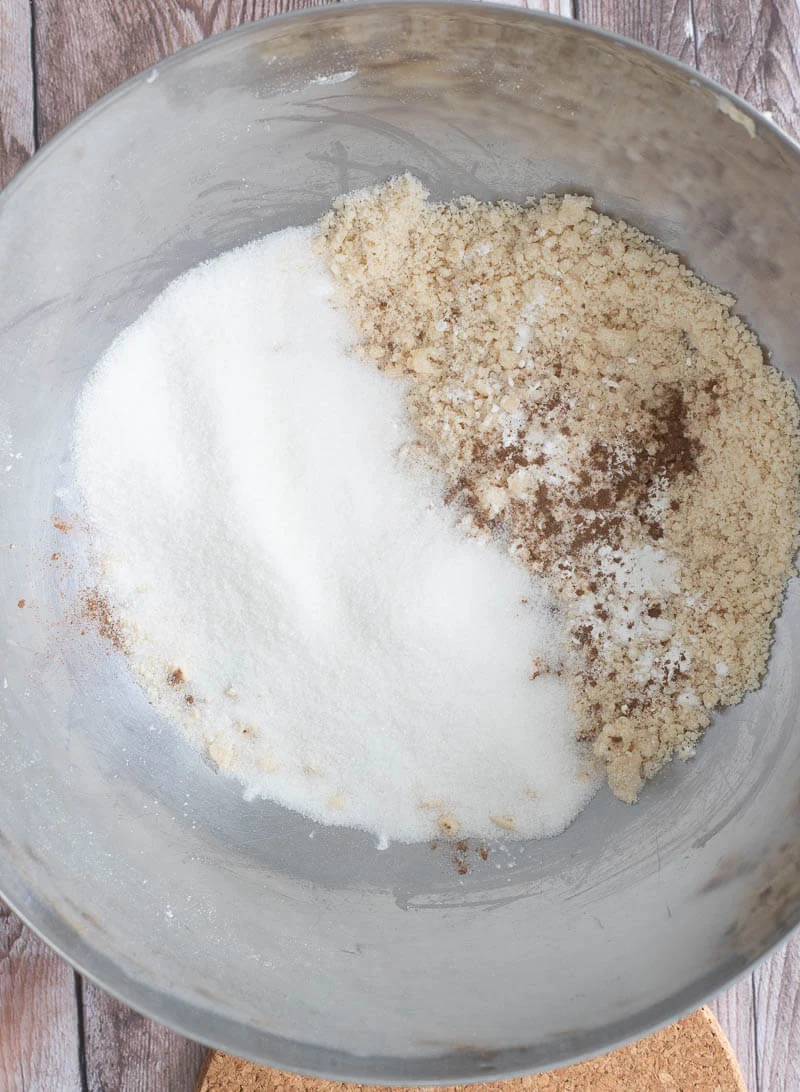 A silver bowl with mixed flour, butter, sugar, and spices.