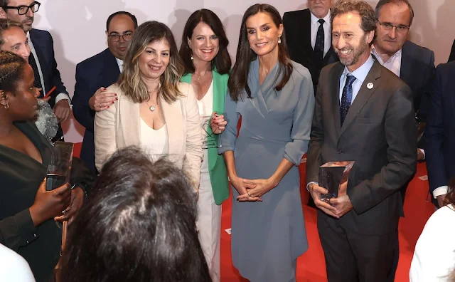 Queen Letizia wore a wrap around dress with side lacing by Adolfo Dominguez. Furla bag and Magrit pumps