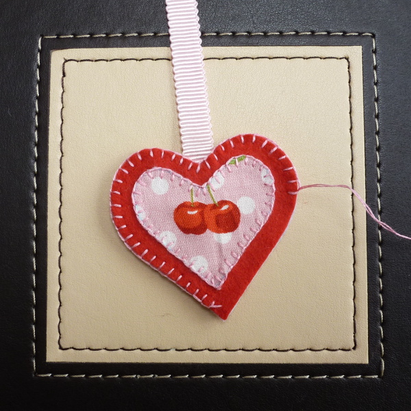 Sewing blanket stitch around the heart shaped felt ornament