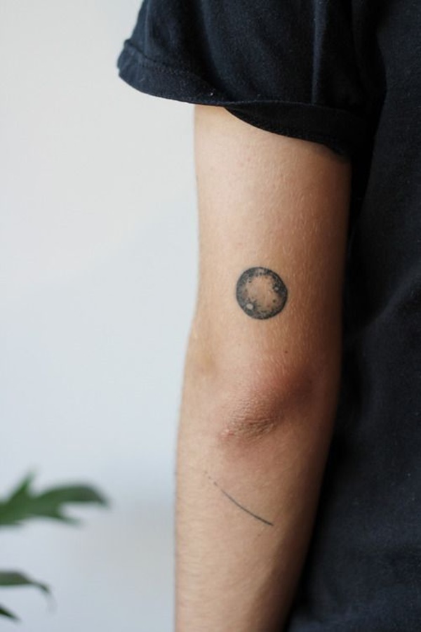 Uma miniatura preto e cinza lua está representado na parte de trás do utente deixou o braço logo acima do cotovelo neste tatuagem.