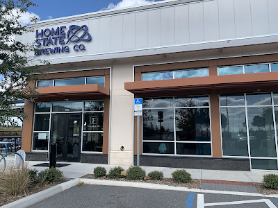 The front door to Home State Brewing Company, a store front with glass windows.