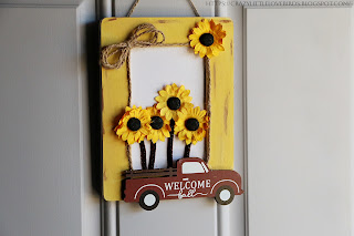 Painted Yellow picture frame with yellow sunflowers and red truck decoration hanging on a door