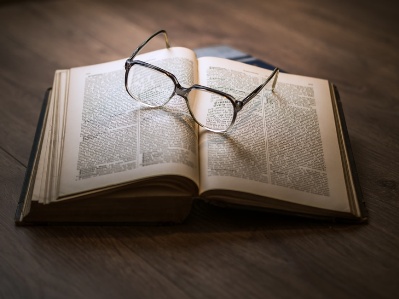 A photo of a pair of open reading glasses on the pages of an open book