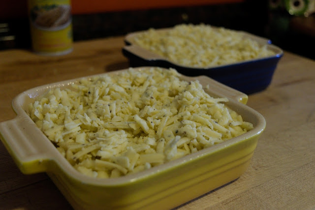 The mac and cheese in the baking dishes, topped with more truffled cheddar cheese.