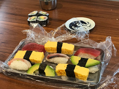 Several nigiri sushi on plastic wrapping