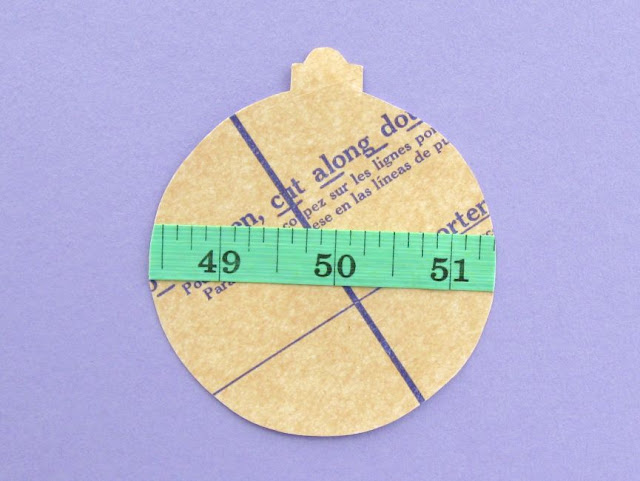 Paper bauble decorated with sewing pattern and measuring tape