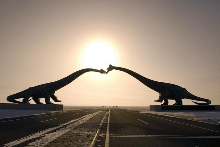 The Kissing Dinosaurs of Erenhot in China North of China on the Sino-Mongolian border, near the town of Erenhot (also known as Erlian), you will find the statues of two towering Brontosauruses. The two dinosaurs are located on either side of the main highway, their long necks stretching to the other, until the two dinosaur's mouth meet as if to share a kiss. Each dinosaur statue is 34 meters wide and 19 meters high. The span of the two together reaches 80 meters. The ground near the kissing couple is littered with many dozen smaller statues of dinosaurs of all shapes and sizes.
