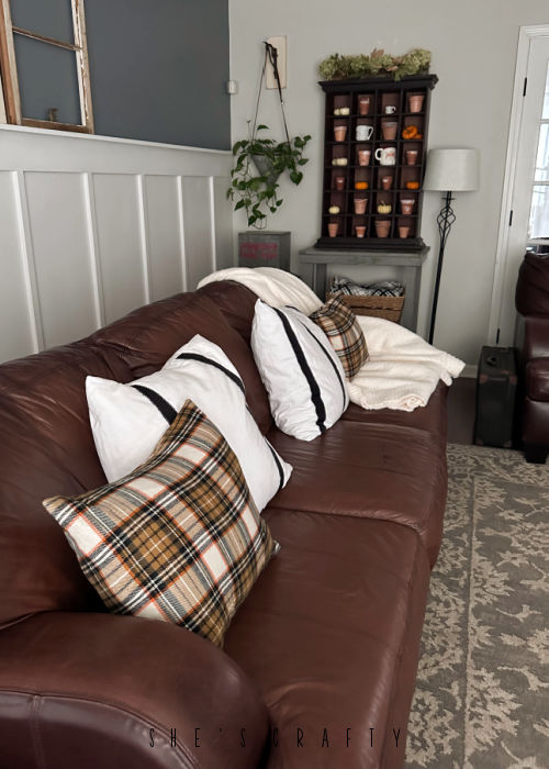 Throw pillows on brown leather sofa.