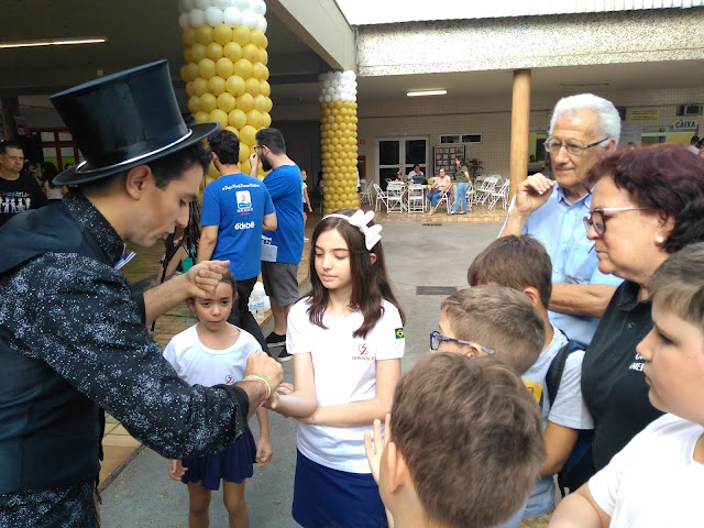 Artista de Humor e Circo interagindo com truques de mágica com o público de evento do dia das crianças.