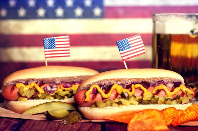Two hot dogs with mustard, onions and gherkin on the table at RJ's American Diner in Ashford