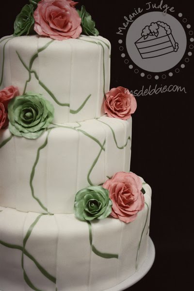 white fondant wedding cake green swirls with green and pink roses