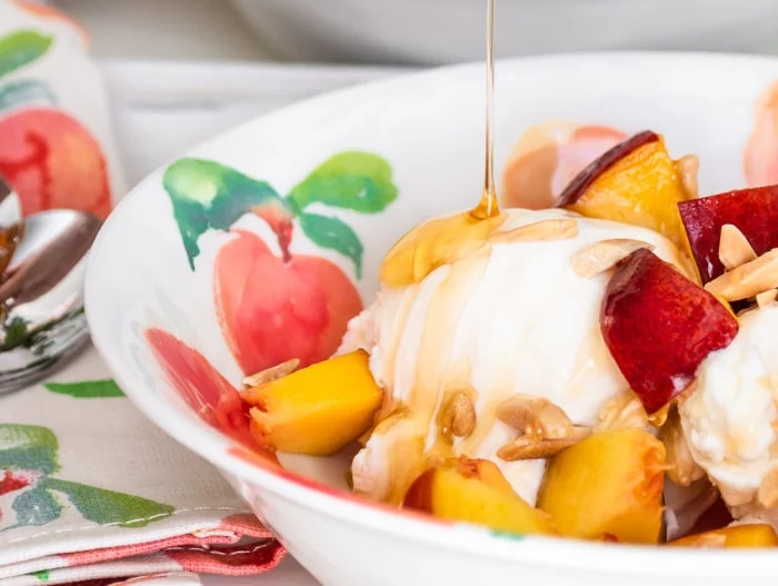 drizzling warm honey over fresh peaches, toasted almonds, vanilla ice cream