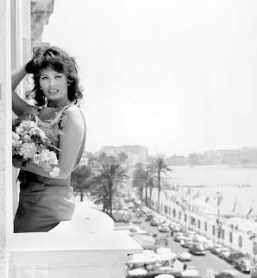 Sophia Loren poses with flowers on the balcony of her Cannes hotel on May 13