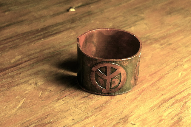 Peace sign etched into a copper ring