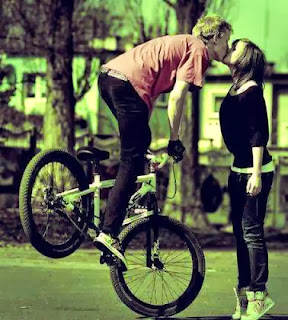 boy kissing girl in bicycle Cute kiss