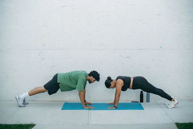 Man and woman performing Knee-to-Elbow Planks in low impact HIIT exercises