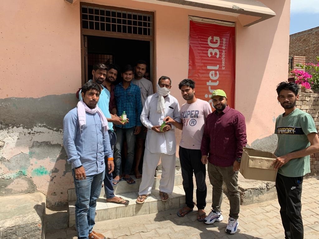 मिलगेट एरिया में लोगों को सेनेटाइजर वितरित करते सुनील रावत व युवा जजपा के सदस्य।