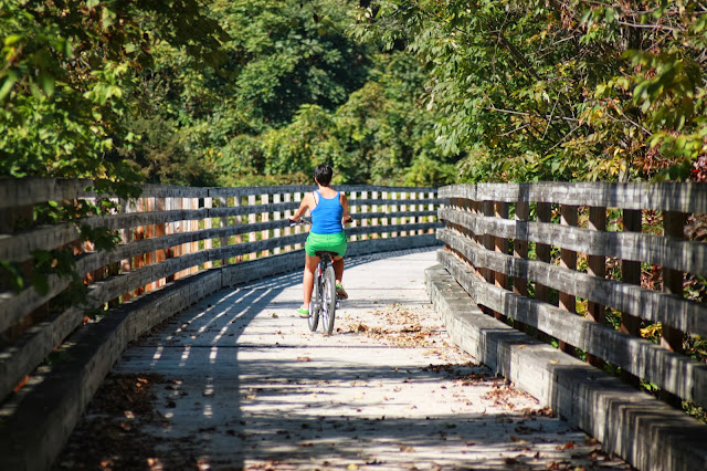 Kristina riding bike on wooden bridge