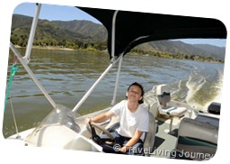 My son is driving the boat on the lake