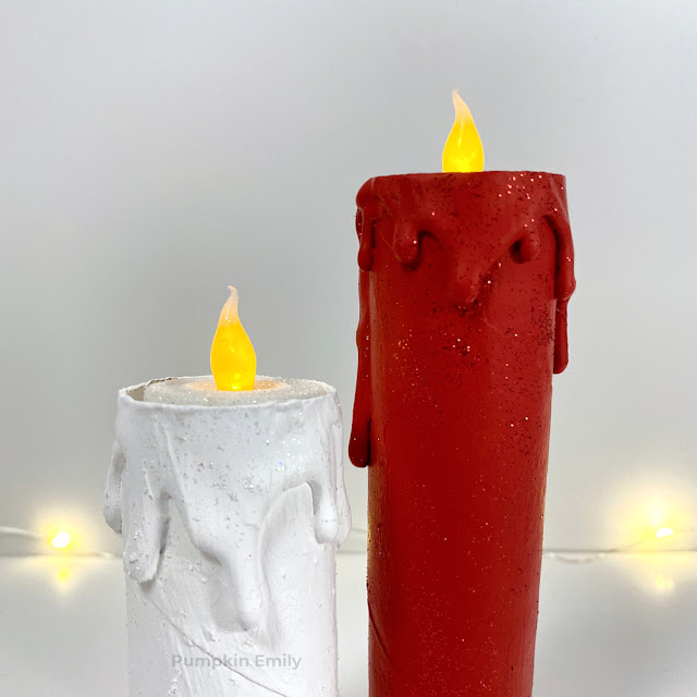 A close up of a red and white paper roll candle.