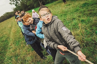 Children playing tug of war in a field