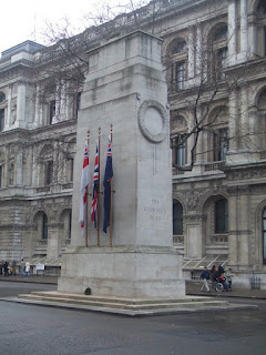 Photograph of a cenotaph, with three UK-related flags attached, showing the large inscription "THE GLORIOUS DEAD"