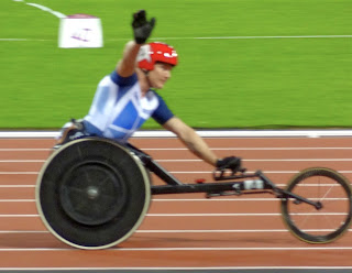 Close up pic of paralympian Dave Weir with his right arm raised in victory at London 2012